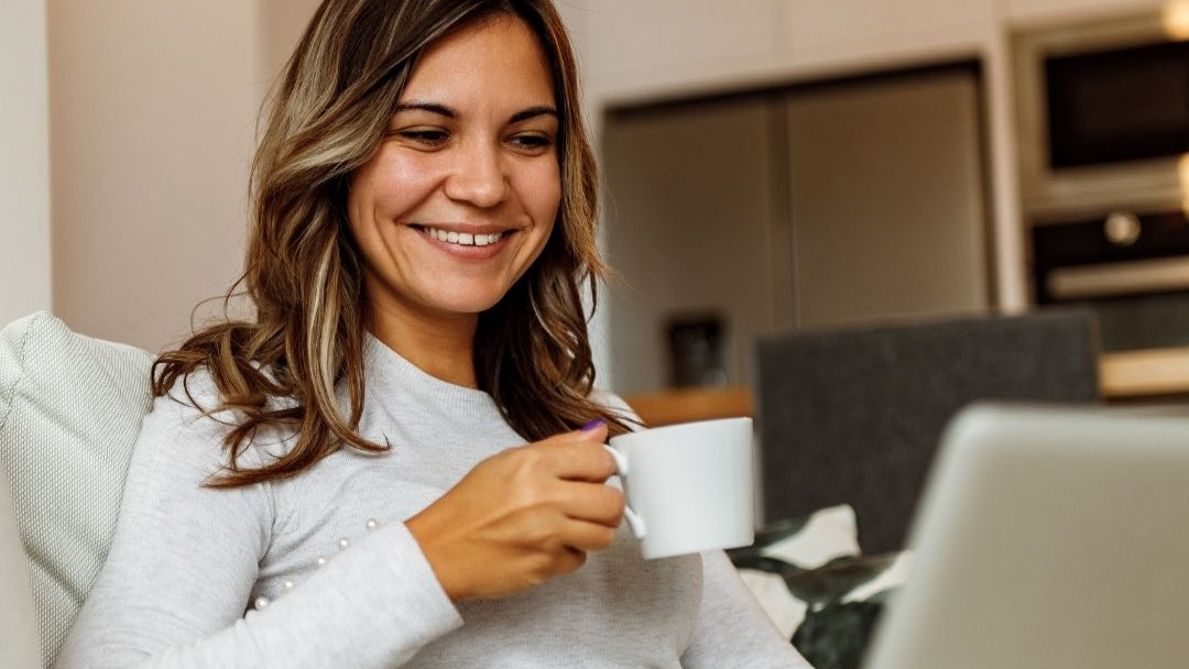 Smiling woman working at laptop with focus and energy from GeneIII L-Ergothioneine supplement