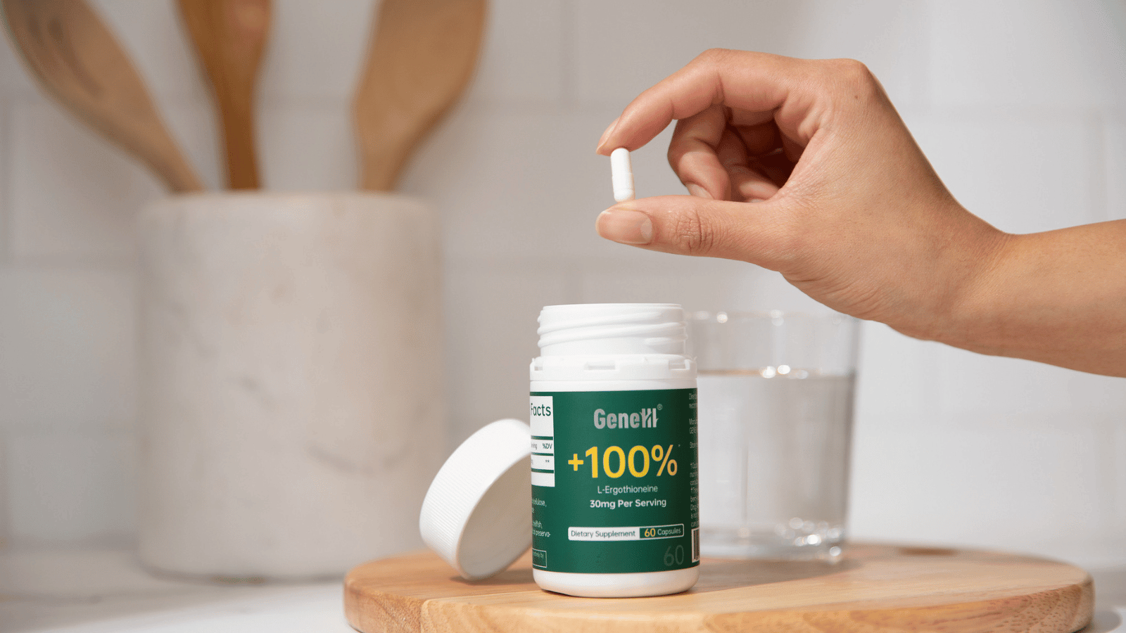  Hand placing a GeneIII L-Ergothioneine 99.99% pure capsule bottle into a daily preventive anti-aging supplement routine